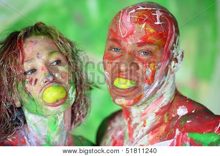 Portrait of man and women all in the paint with lime in the mouth