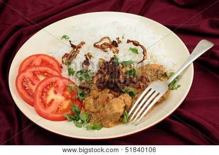 The popular south-Indian variant of Chicken Korma, incorporating coconut, served with boiled basmati rice and garnished with coriander leaves, fried onion and sliced tomato.