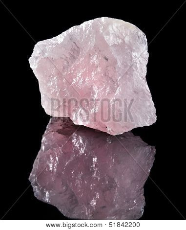 Natural Rose Quartz crystal with reflection on black surface background 