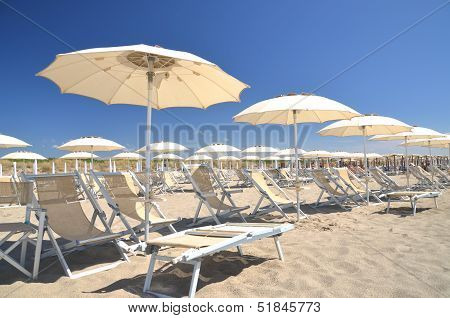 Beach umbrellas and chairs on beautiful beach Marina di Vecchiano nearby Pisa, Tuscany in Italy