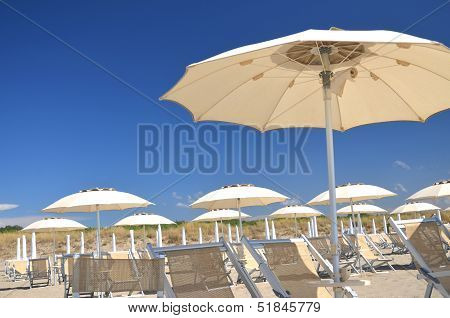Beach umbrellas and chairs on beautiful beach Marina di Vecchiano nearby Pisa, Tuscany in Italy