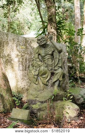 Old ruined Arhat Kanakbharadvaja statue in forest, Taiwan, Asia.