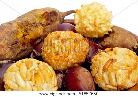 some panellets and roasted chestnuts and sweet potatoes, typical snack in All Saints Day in Catalonia, Spain, on a white background