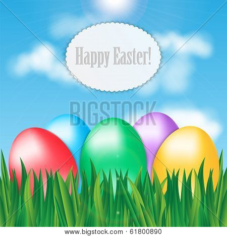 Colorful Easter Eggs On Green Grass On Blue Sky Background And Frame For Your Text