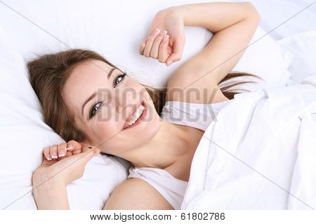 Young beautiful woman woke up in bed close-up