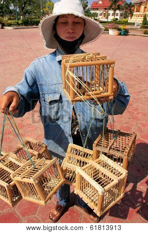 VIENTIANE, LAOS - NOVEMBER 29: An unidentified woman sells birds near Pha That Luang on November 29, 2011 in Vientiane, Laos. Vientiane is the capital and largest city of Laos.