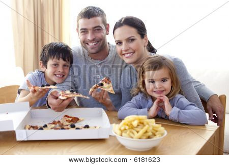 Eltern und Kinder zu Hause essen Pizza und Pommes frites