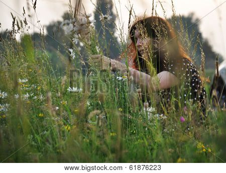 Girl tearing wildflowers in the meadow