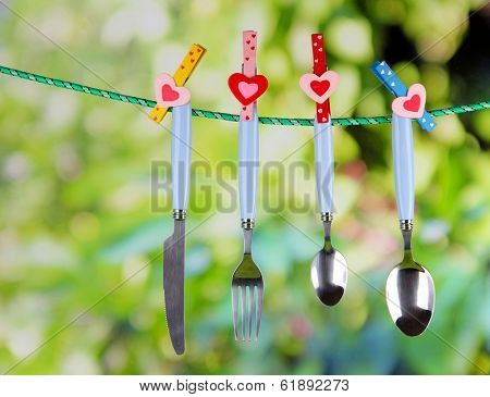 Cutlery dried on rope on natural background