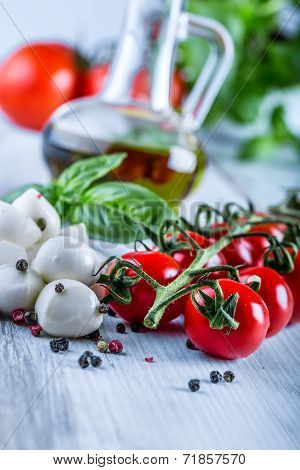 Cherry tomatoes, basil leaves, mozzarella cheese and olive oil for caprese salad.