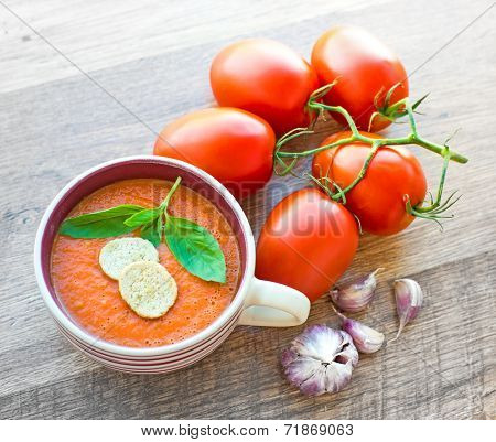 Bowl of tomato soup gaspacho with basil and crackers