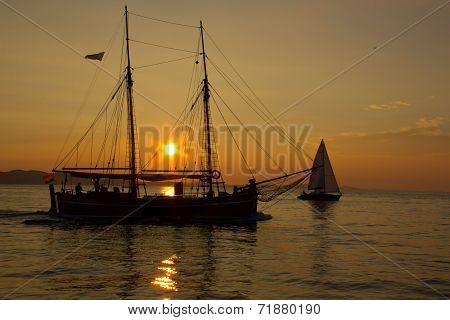 Sailing Into The Sunset With Reflections On The Sea Surface