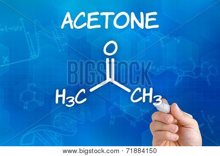 Hand with pen drawing the chemical formula of Acetone