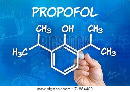 Hand with pen drawing the chemical formula of Propofol