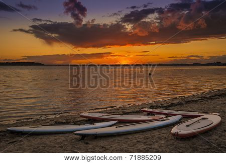 Orange glow of setting sun and calm waters in Poole Harbour