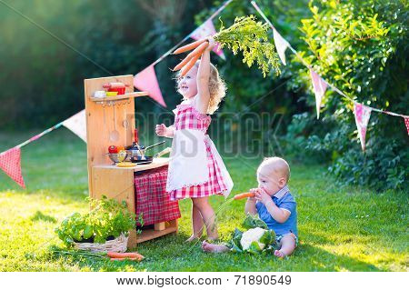 Little Kids Playing With Toy Kitchen In The Garden