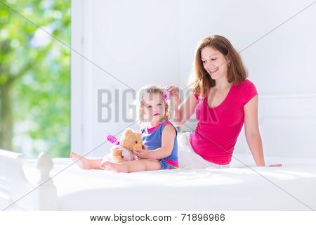 Mother And Daughter Brushing Hair