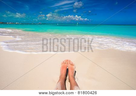Close up of female feet on white sandy beach