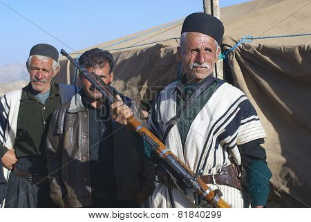 Man in traditional dress holds a rifle, circa Isfahan, Iran.