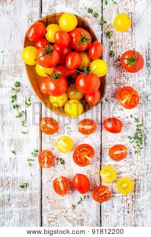 Yellow And Red Cherry Tomatoes With Thyme On Old White Wooden Table