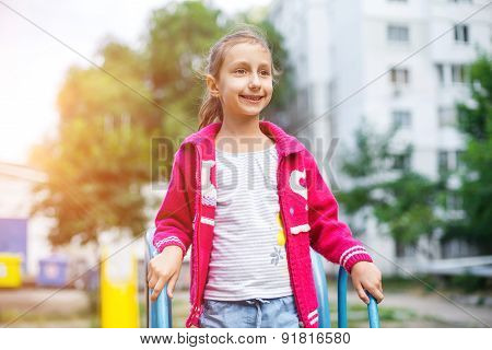Cute little girl is playing in playground, outdoor shoot