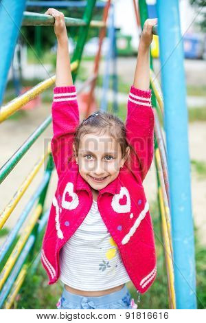 Cute little girl is playing in playground, outdoor shoot