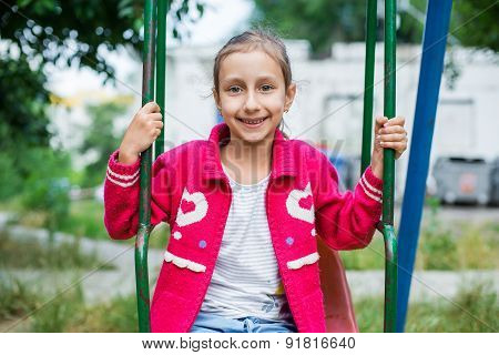 Cute little girl is playing in playground, outdoor shoot