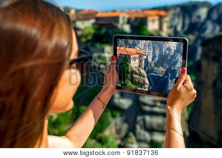 Woman photographing Meteora monastery in Greece