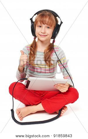 Little girl enjoying music listening in headphones