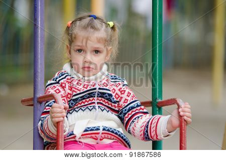 Upset Four-year Girl Riding On A Swing