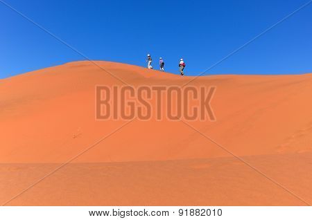 People walking on beautiful dune of Namib desert, traveling and hiking in South Africa