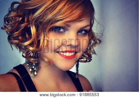Beautiful young woman with elegant short curly red hair style.
