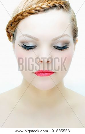 Beauty portrait of a young woman with light skin, evening make-up and braided red hair.