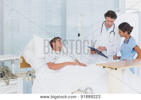 Doctors taking care of patient in hospital room