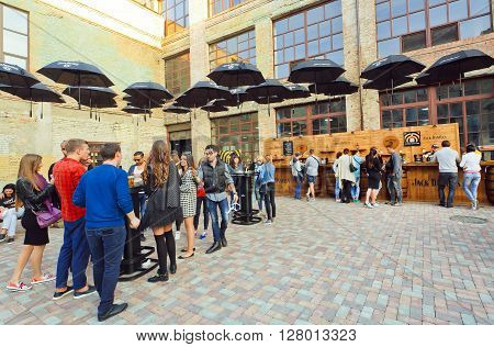 KYIV, UKRAINE - OCT 5, 2015: Outdoor bar with umbrellas and crowd of drinkig people on October 5, 2015. Kiev is the 8th most populous city in Europe.