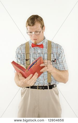 Caucasian young man dressed like nerd reading book.