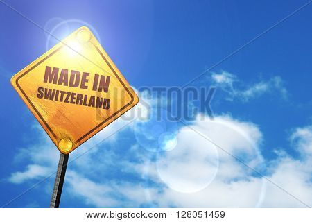 Yellow road sign with a blue sky and white clouds: Made in switz