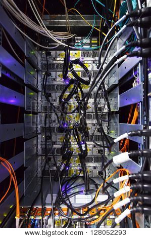 rack in the data center with working equipment with optical and UTP cables