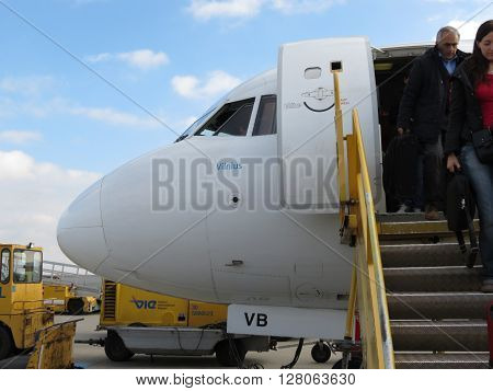 VIENNA SCHWECHAT AUSTRIA - CIRCA NOVEMBER 2014: Austrian Airlines aircraft at the airport with passengers unboarding