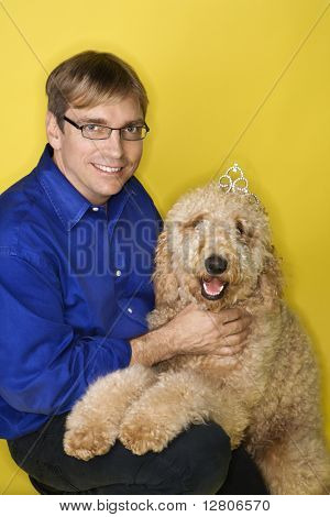 Kavkazská muž středního věku s Goldendoodle psem.