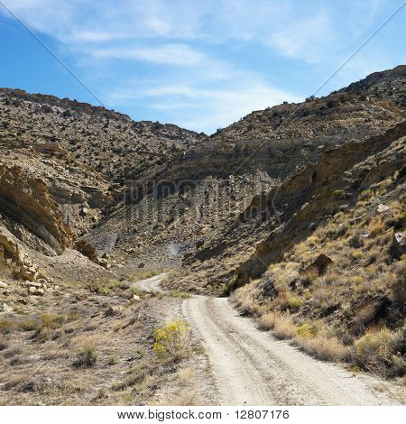 Dirt road winding through rocky desert cliffs of Cottonwood Canyon, Utah.