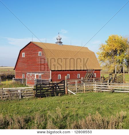 Red barn and fence in field.