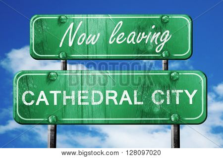 Leaving cathedral city, green vintage road sign with rough lette