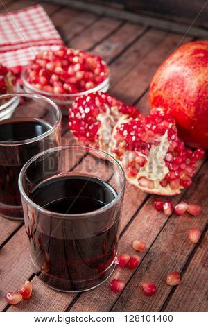 glass of pomegranate juice with fresh fruits on wooden table