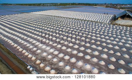 aerial view Heap of sea salt in original salt produce farm make from natural ocean salty water preparing for last process before sent it to industry consumer