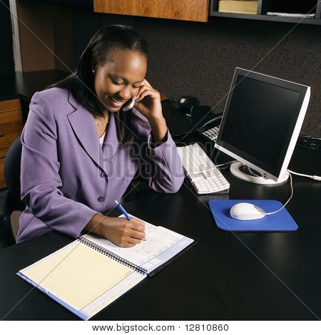 High Angle View of African-American young adult Business Woman am Handy sprechen und Schreiben in 
