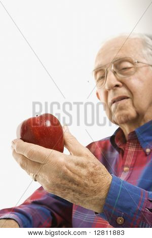 Lüneburg älterer Mann Blick auf roter Apfel in der Hand.