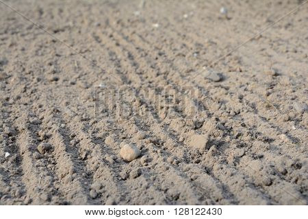 Photo of loosened soil with blurred foreground and background. Shallow depth of field.