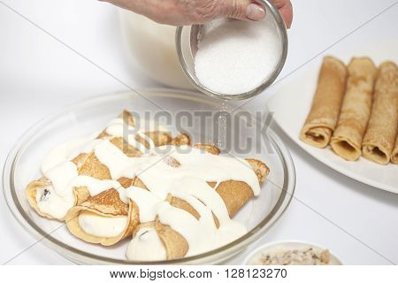 Sprinkling sugar over the topfen füllen crepes