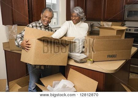 Mittleren Alters afroamerikanischen paar Verpackung bewegen Boxen in Küche.
